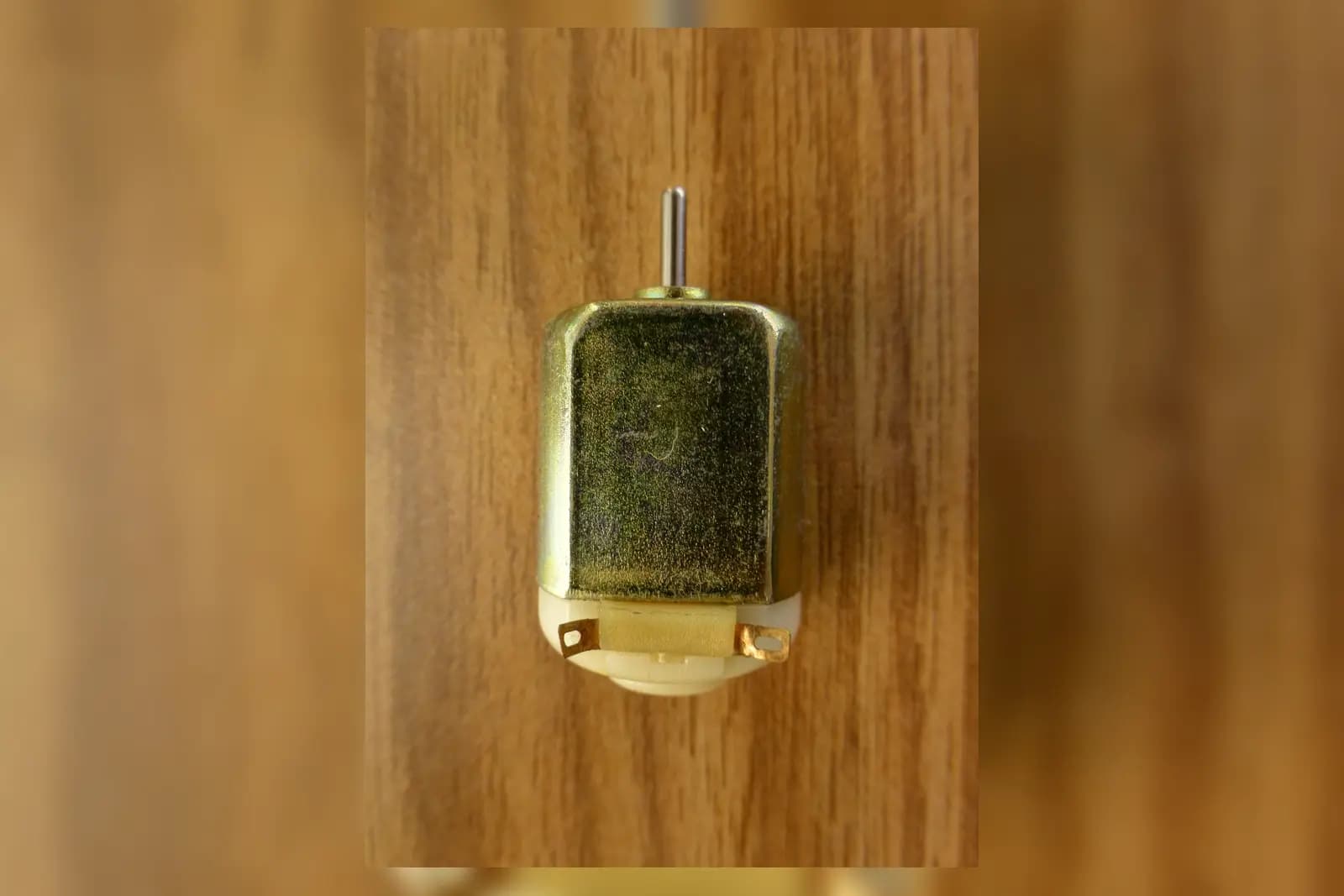 Representative compact brushed DC motor with shaft and terminal tabs visible